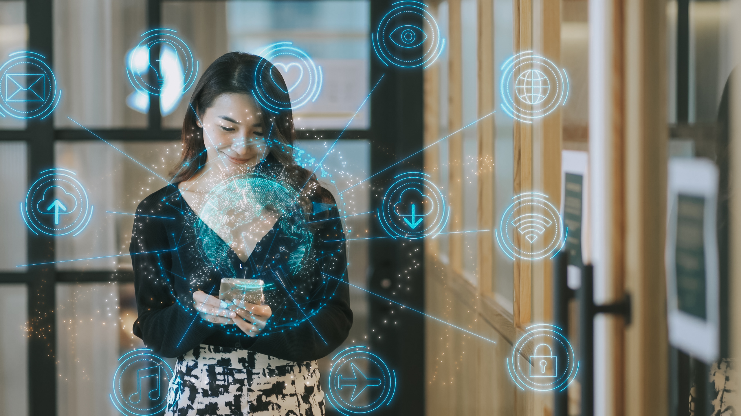 A young woman holds a smartphone as graphics beam out from the device signifying smart devices and connectivity