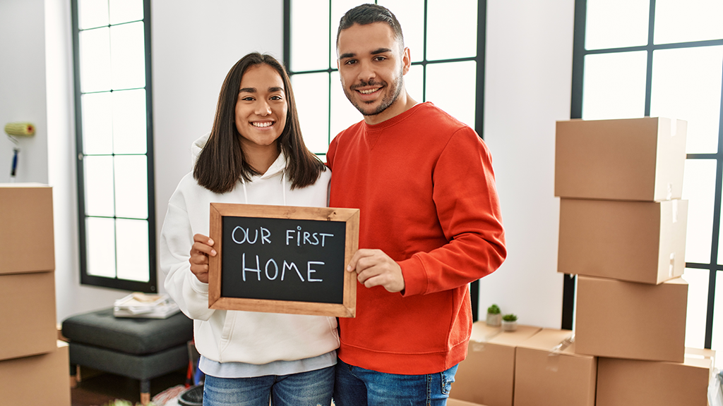 A young couple holding a sign that says 