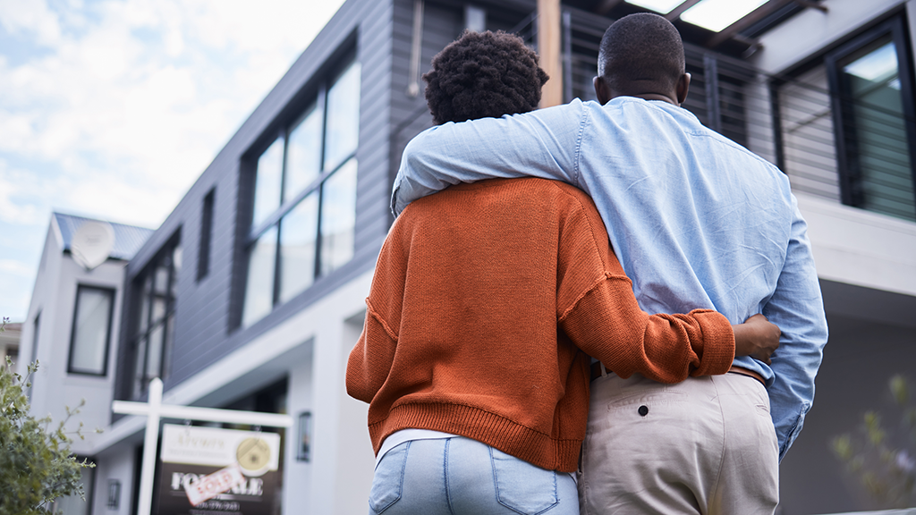 A couple look upward on their newly purchased house