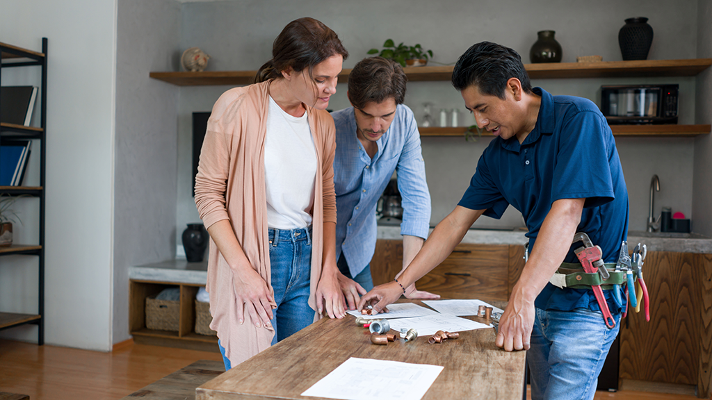 A couple discuss remodeling plans with a contractor in their living area