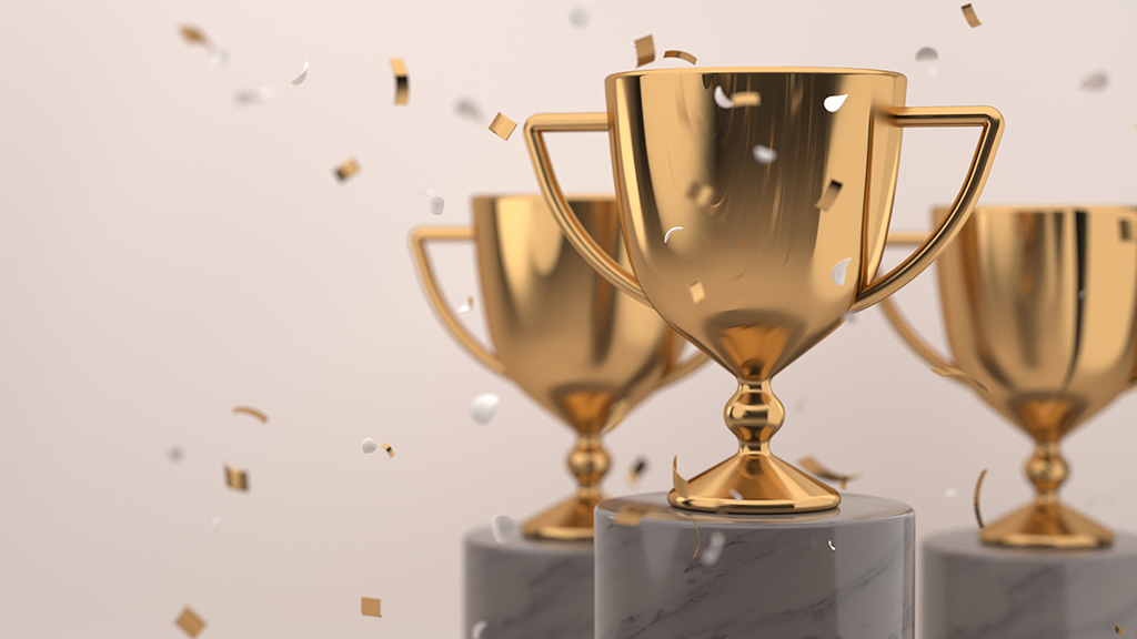 Three digital awards sit on pedestals with confetti