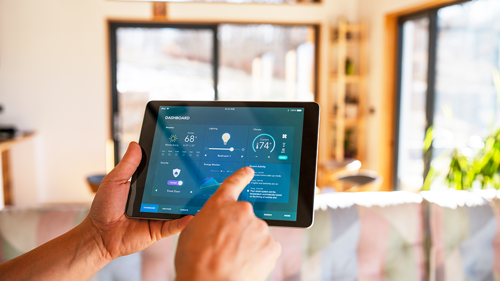 A person holds a tablet that controls smart home features