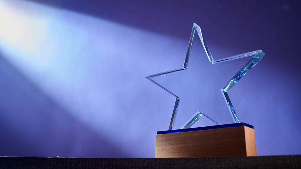 A spotlight shines on a star-shaped award sitting on a table