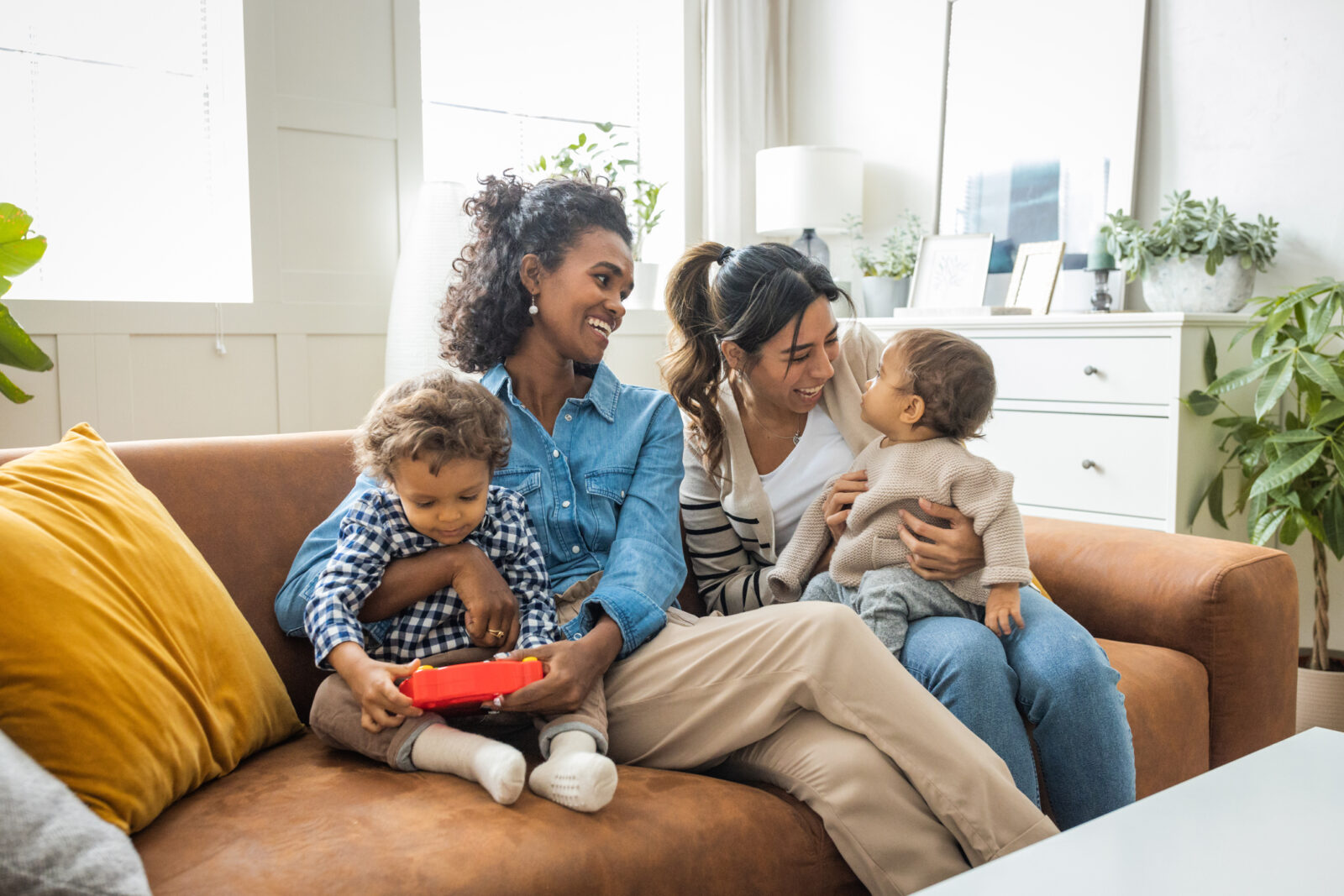 Young mothers playing with children in a modern living room.