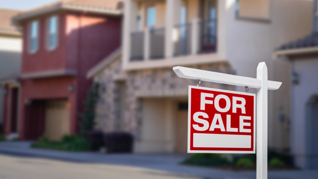 A for sale sign in front of townhouses