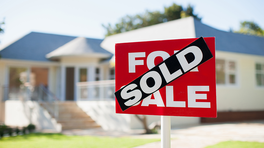 A small sold sign covers a for sale sign