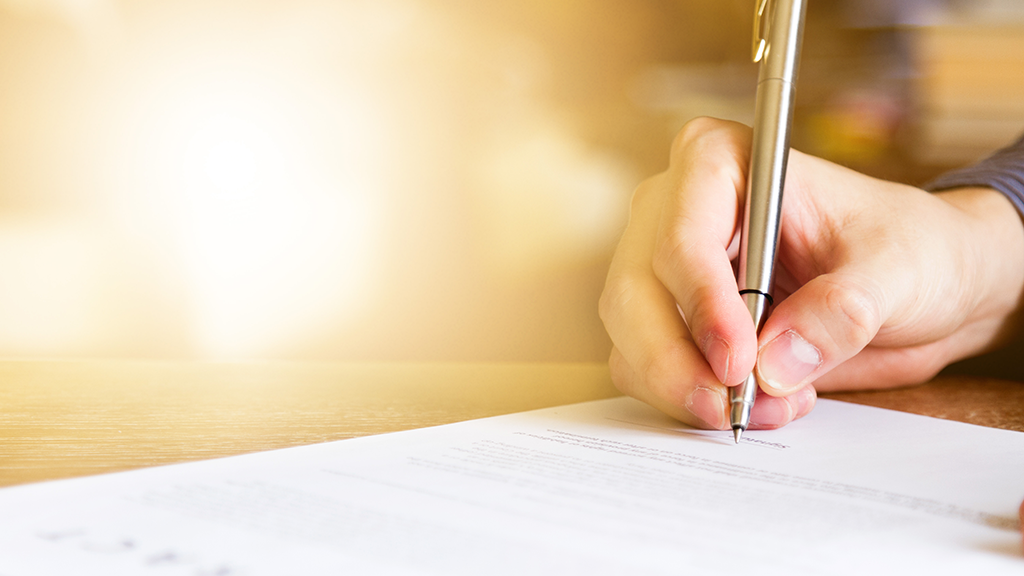 Close-up of person signing a document