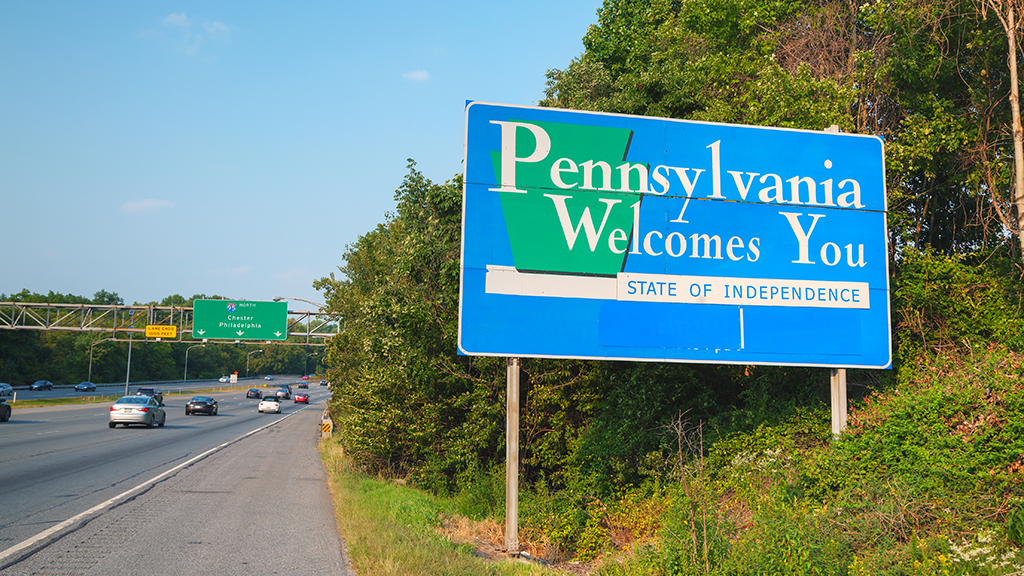 A large sign along a highway reads 