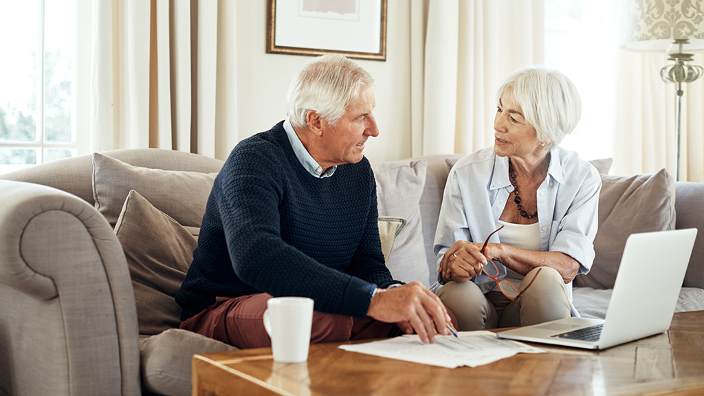 Older couple having a serious discussion over documents and a computer