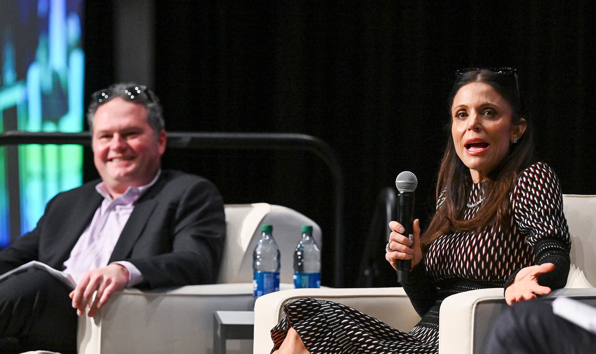 Bethenny Frankel speaks on a panel with Christopher Beadling in the background